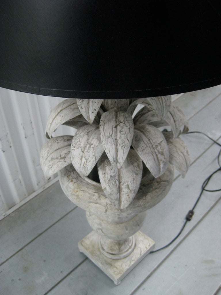 A tole metal plant-shaped table lamp with urn base. Distressed painted gray finish. New black paper shade. Double cluster bulb configuration. Wired and working. 

Shade dimensions: 11 inches wide at top, 20 inches wide at bottom, 14 inch slant.