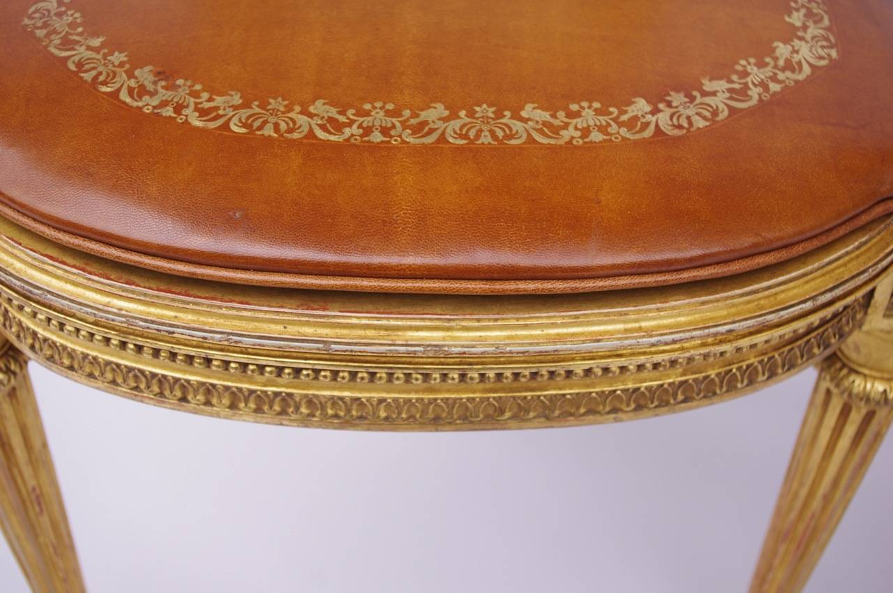 . Carved gilt and cane wood
. Louis XVI style
. Raised on round taperinf and fluted legs
. Brown leather seat
. Original gilt patina
. Circa 1880