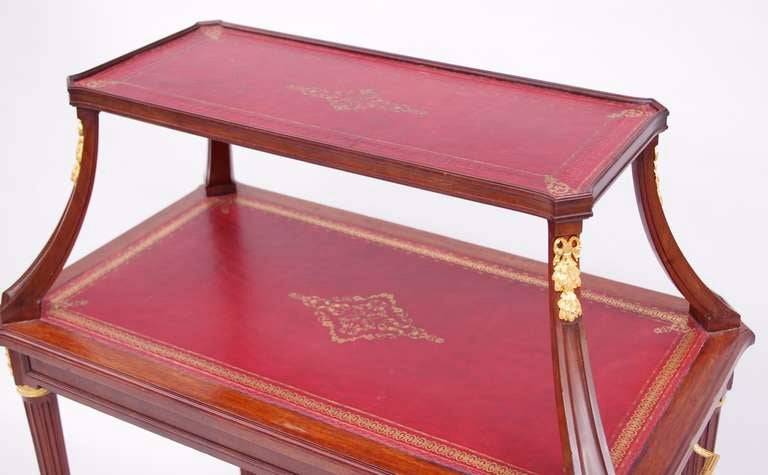 Louis XVI style mahogany and gilt bronze tea table. It stands on four truncated fluted legs, decorated by a ring in the upper part and by a sphere and laurel leaves hoof. The junction parts are decorated with acanthus leaves roses, and beribboned