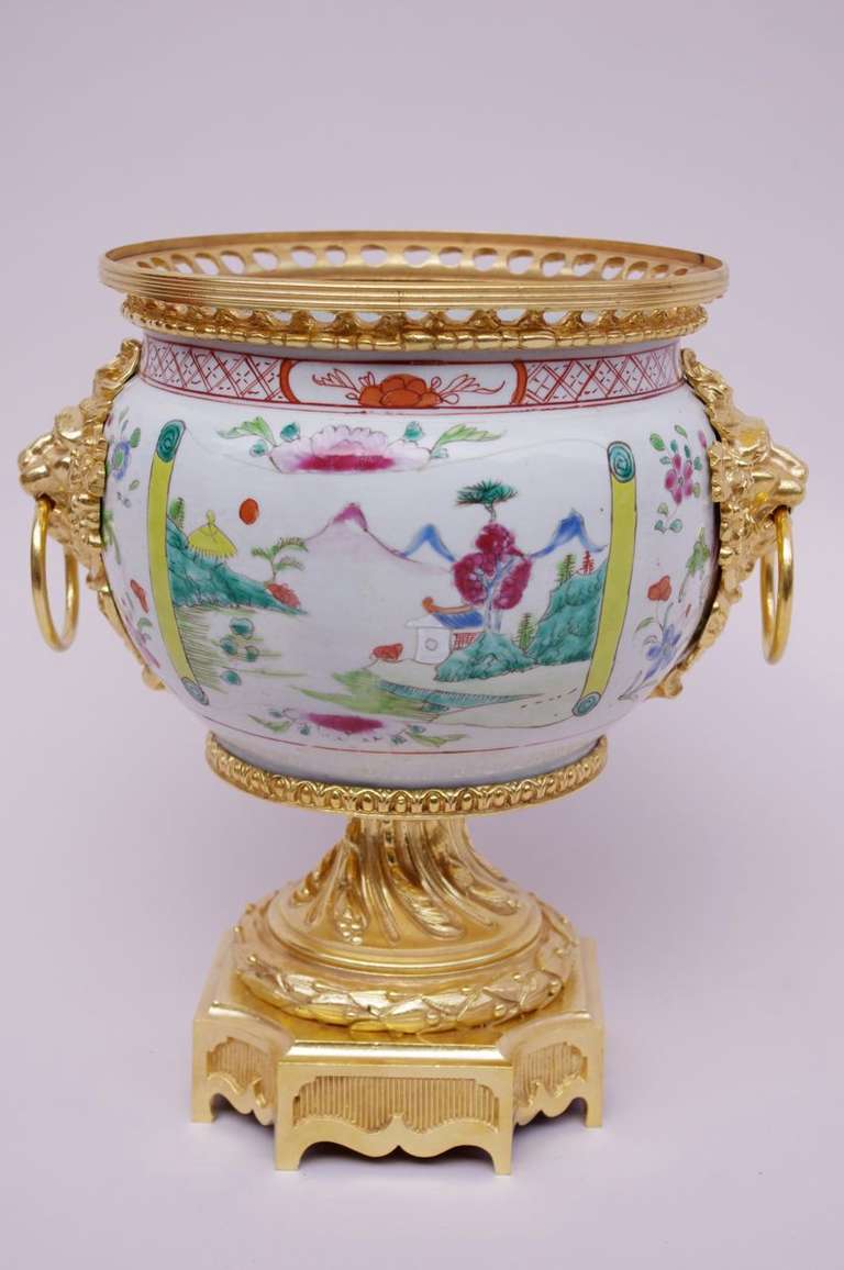 Bulged Canton Porcelain with a white background and decoration of landscapes in reserve in the yellow, green, blue and red tones. Between them near the collar, flowers like eyelets, poppies and iris rhythm the ensemble. Chiseled and gilt bronze
