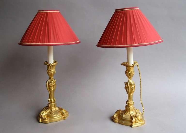 Pair of chiseled and gilt bronze Rocaille style candlesticks mounted in lamps and standing on an asymmetrical base with guilloche. The central support is made of curved volutes topped by a candle where the light bulb takes place.
Work made circa