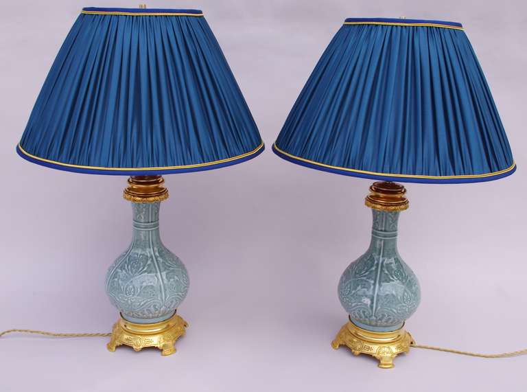 19th c. pair of bas relief sculpted celadon porcelain lamps
