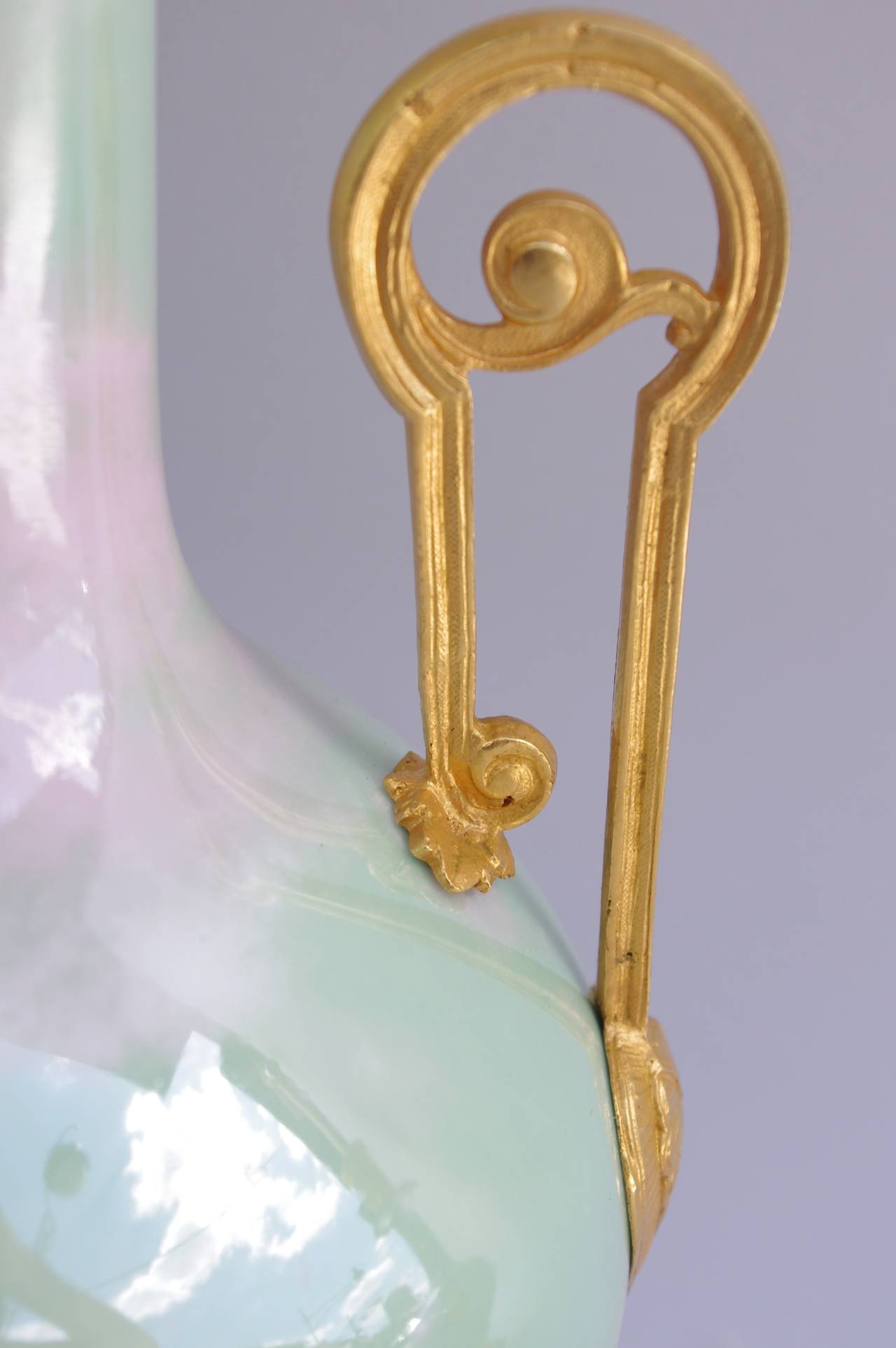 Paar Lampen aus irisierendem Seladon-Porzellan mit Flaschenschirm. Ziselierte und vergoldete Bronzemontierung auf einem durchbrochenen Rundsockel mit Kartuschen und Wirbeln, zwei durchbrochenen Griffen und Akanthusblättern in der Nähe des