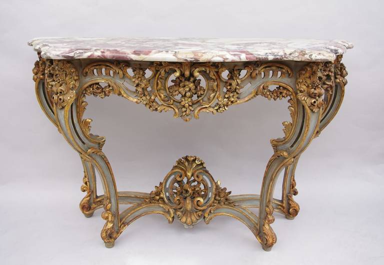 . Sculpted wood and openwork.
. Grey or green patinated lacquer with gilt highlights.
. Decor belonging to Rococo style such as godrons, openword shell, flowers garlands.
. Brèche marble top.
. Standing on four feet gathered by an entretoise