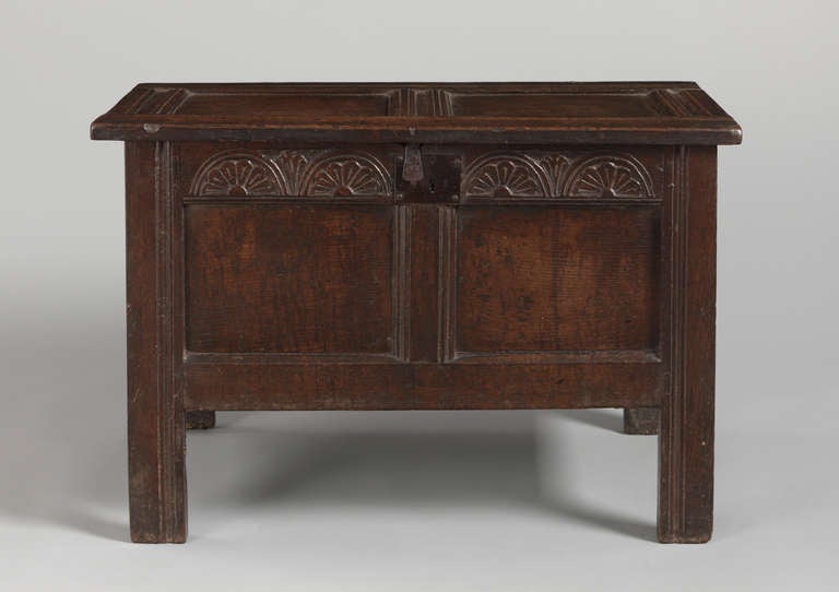 With fine lunette carved frieze. 
Solid richly patinated and burnished oak,
English, circa 1670.
Measures: 29” high x 39” wide x 18” deep.

An unusually small and well drawn early panelled chest, this well proportioned piece boasts an rich