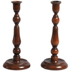 A Pair of Early Yew Wood Table Candlesticks