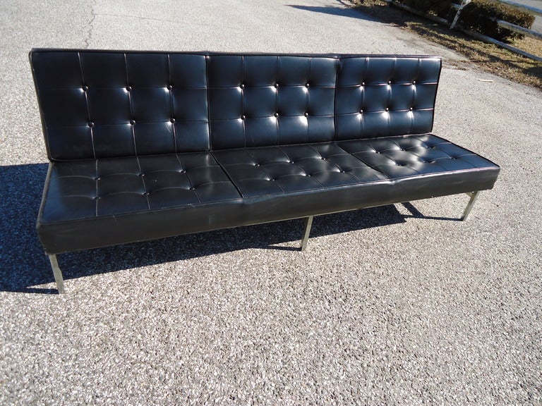 This parallel bar armless Knoll style sofa has its original black vinyl upholstery. It is made of Solid steel case construction and is very heavy. This Barcelona style sofa would complement any home or office with its iconic design and its long