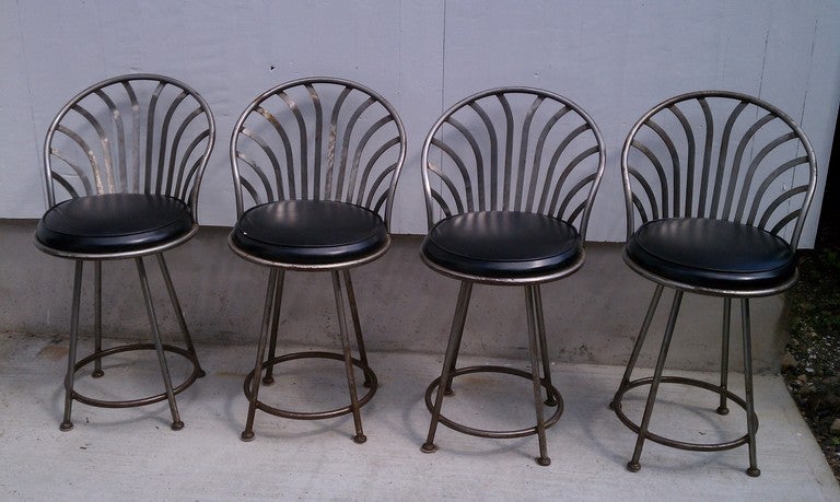 This Set of Shaver Howard/ Arthur Umanoff Stools are made of steel with an antiqued finish  with rusting overtones. They are all hand forged.  They have  their original black vinyl upholstery and  swivel . They include the maker label. Ideal height