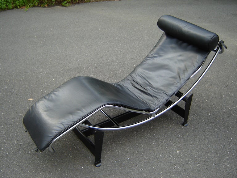This iconic LC-4 chaise designed by Le Corbusier and Charlotte Perriand is manufactured by Cassina the sole authorized maker. It has it's original Black Leather upholstery body and headrest.This chaise features a matte black steel base that is