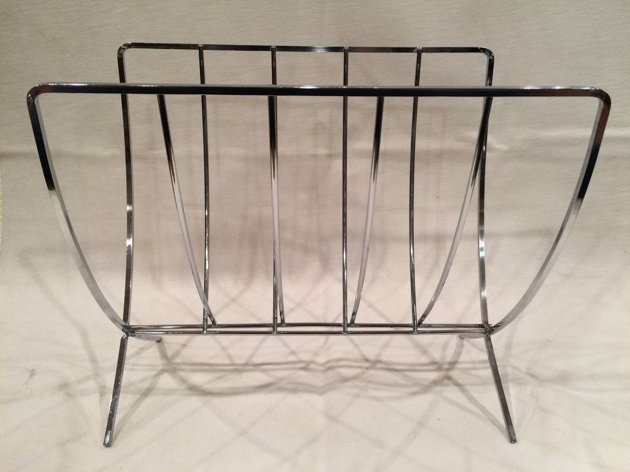 Mid Century Modern Chrome Magazine Rack. Hinges to fold in and out. One small spot of tarnish. Perfect for your Dwell or Architectural Digest magazine.