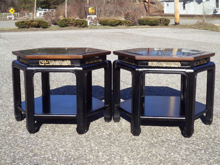 Pair of Asian Chinese Chippendale tables in the style of James Mont but produced by Kittinger. Hexagonal in shape and accentuated by brass fretwork with black marble tops.
