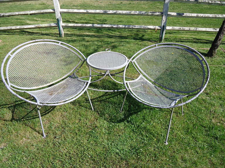 Rare Mid Century Modern  clamshell Tete a Tete by Maurizio Tempestini for Salterini.  Made of iron this practical and classic design has a connecting table as well as an umbrella holder to offer shade. 