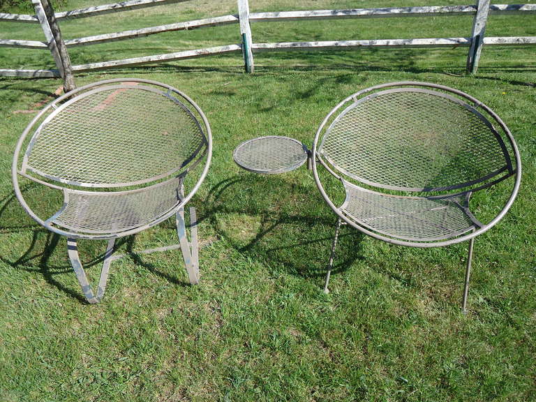 These Maurizio Tempestini for Salterini clamshell chairs are iconic in design. One is a cantilever chair, the other is a four legged clamshell chair with attached side table. These are perfect for any patio, garden or rooftop setting. They would