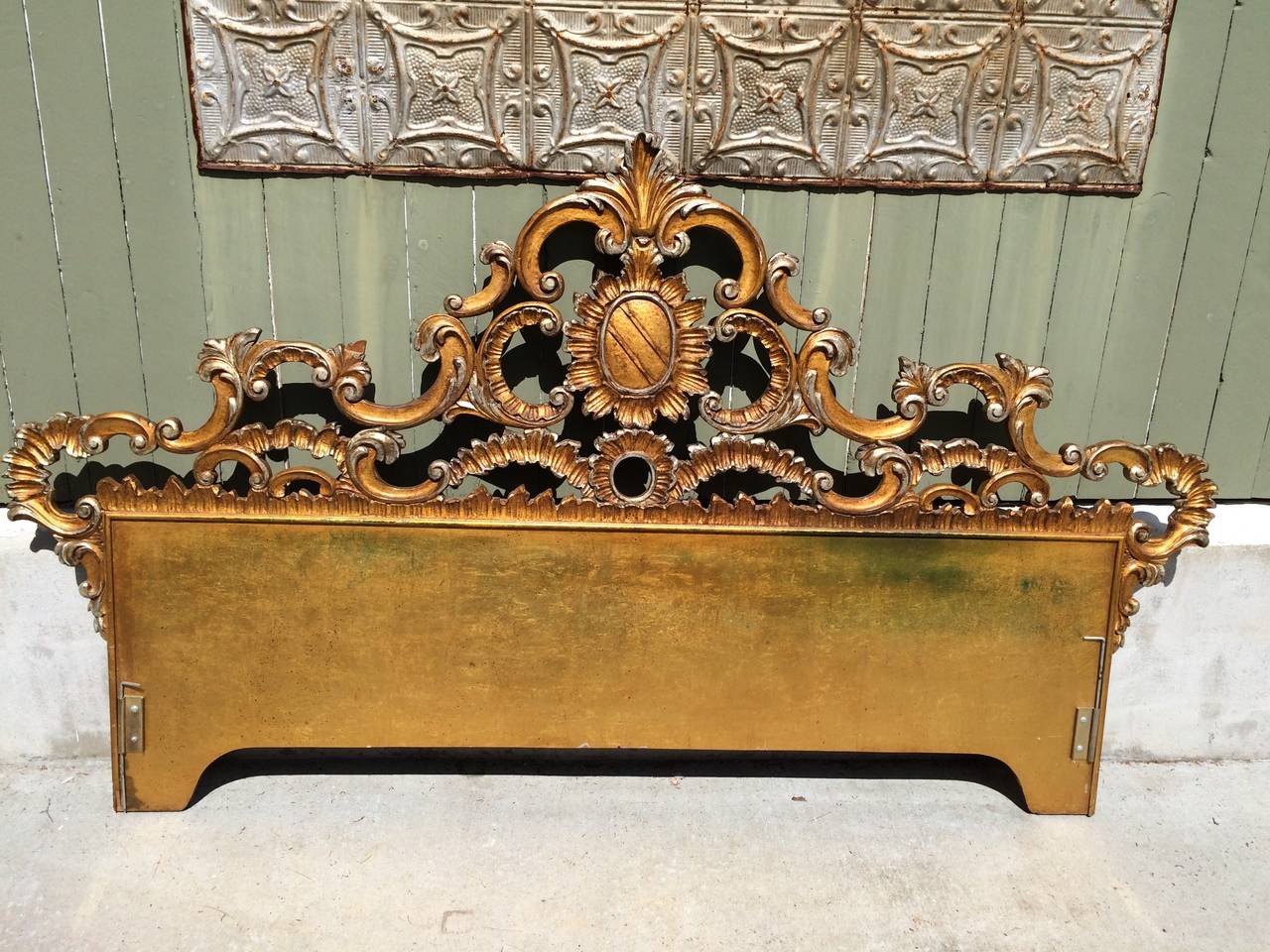 Carved gilt king headboard in gold gilt with silver gilt accents. This regal headboard with crest will make any room majestic. Most likely hand-carved and made in Florence, Italy. Or it could be by Kargas Furniture Company. The headboard attaches