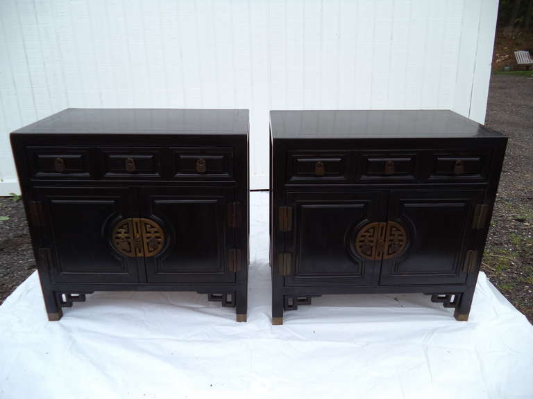 Pair of Chinese Chippendale cabinets in the style of James Mont or Ray Sabota for Century. Accentuated by chunky Greek Key brass hardware and faux bamboo style fretwork trim.  Great as nightstands or end tables. Matching credenza or dresser has sold.