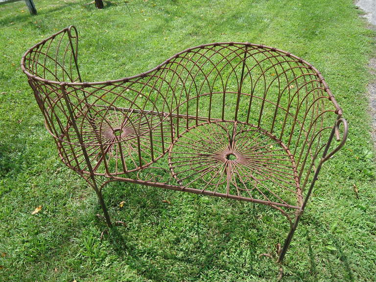 Classic sculptural garden tete a tete in iron. This piece would be a great focal point for a garden. This romantic, Victorian style bench is often called the courting bench allowing a couple to sit facing each other for greater intimacy of