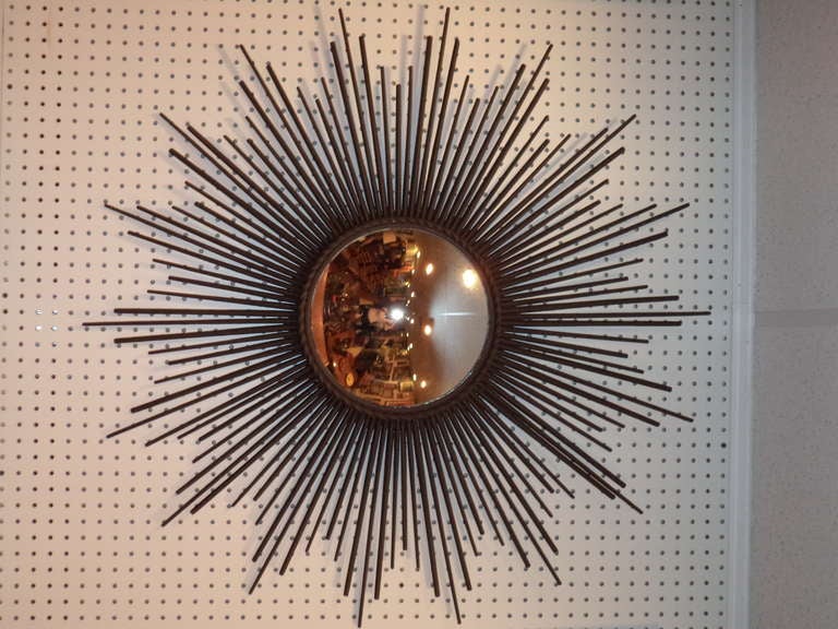 Mid Century Modern Starburst Mirror. This stunning piece will complement any room. The mirror is convex and has a rich mercury glass feel to it. The metal is heavy like iron tole ware.