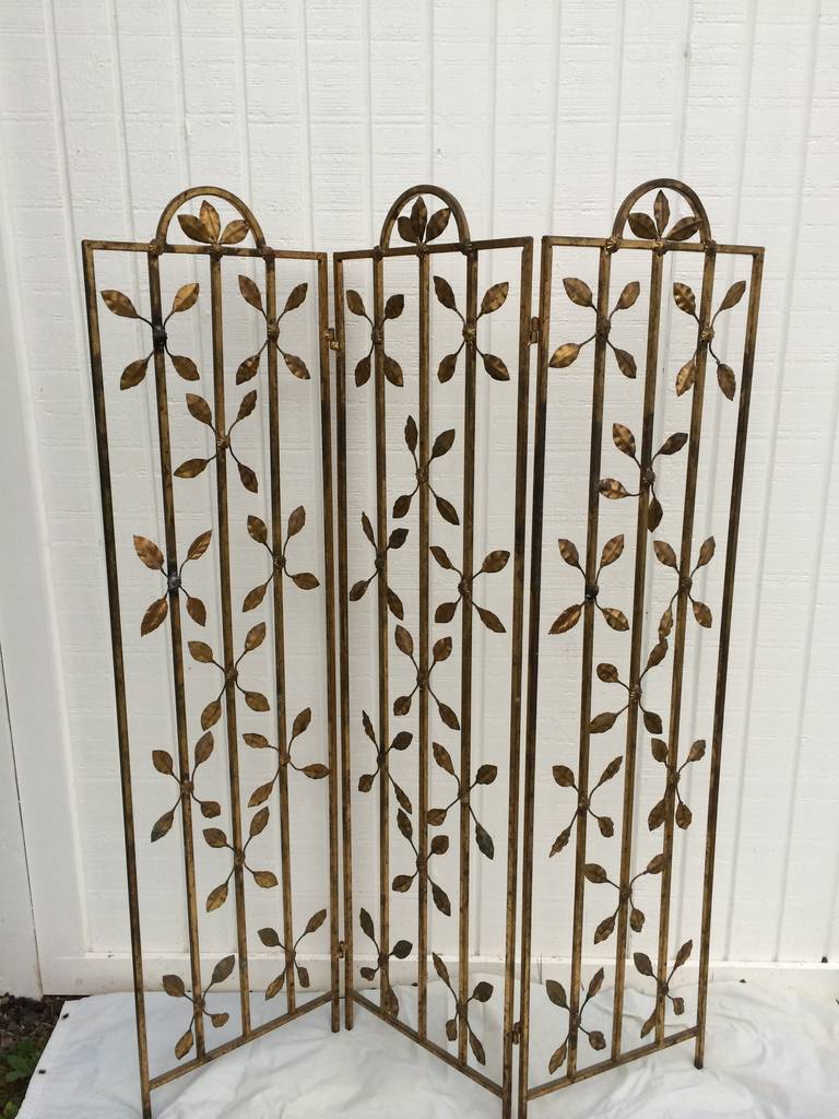 Gilt iron folding screen with three panels decorated with floral leaves. Elegant decorative screen to add texture to any room. Most likely Italian. Folds up for easy shipping.