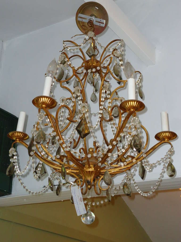 Gilded iron and crystal chandelier with smoked color crystals.