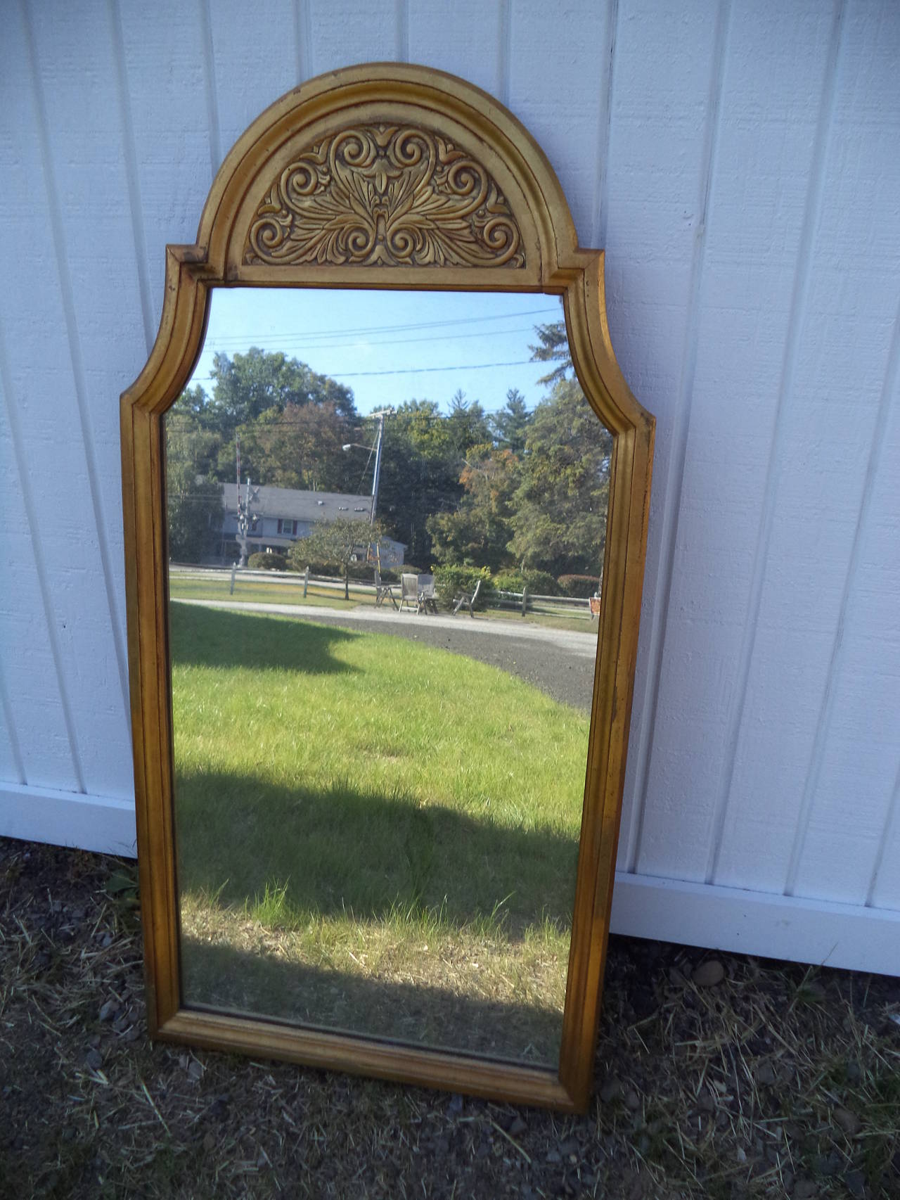 Hollywood Regency gilt wooden mirror with a Mediterranean flair.  Excellent condition. One sale as we have no more wall space.