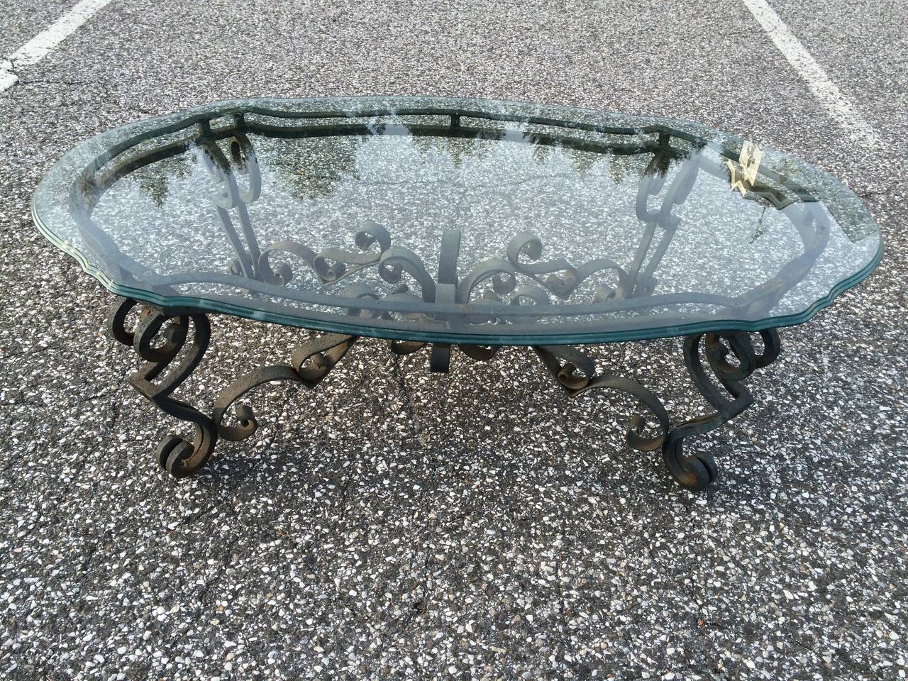 Hand Wrought Iron and Glass Coffee Table. Incredible detailed scroll work makes up this table.This French style piece is topped with a thick piece of scalloped and triple beveled glass.
Currently with a black matte finish, this could also be gilded