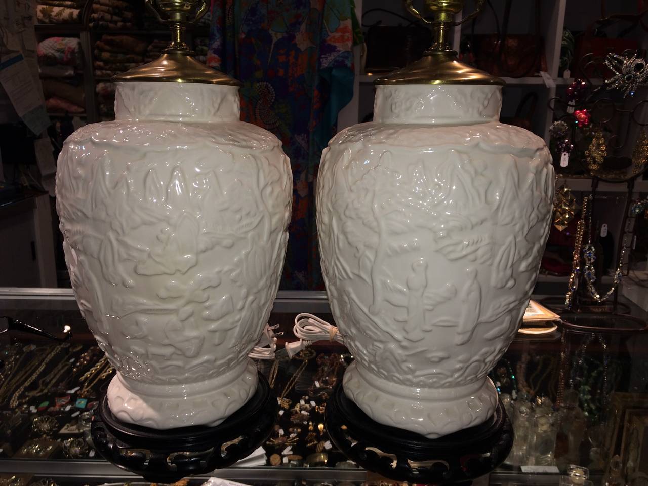 Pair of white embossed Chinese Chippendale ceramic lamps. These would go great in any traditional home or with any Dorothy Draper style decor. Teak wood carved bases.