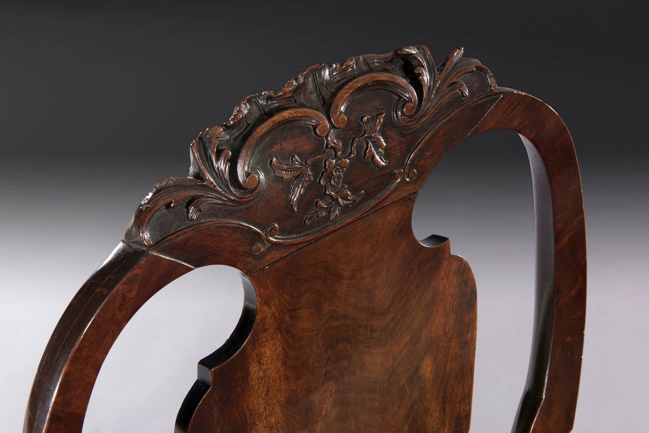 This 18th century carved mahogany chair has fine rocaille carving on the crest and cabriole legs and a splate tapestry drop in seat.