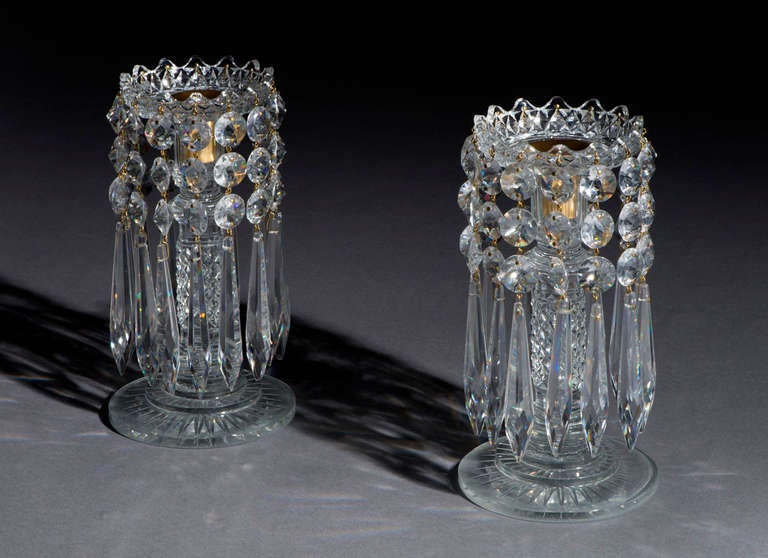 Each lustre has a radial cut base, diamond cut column base and a granulated rim. They are hung with round icicle drops each with three flat round spangles. 

The lustres are attributable to John Blades who opened his showrooms at 5 Ludgate Hill in