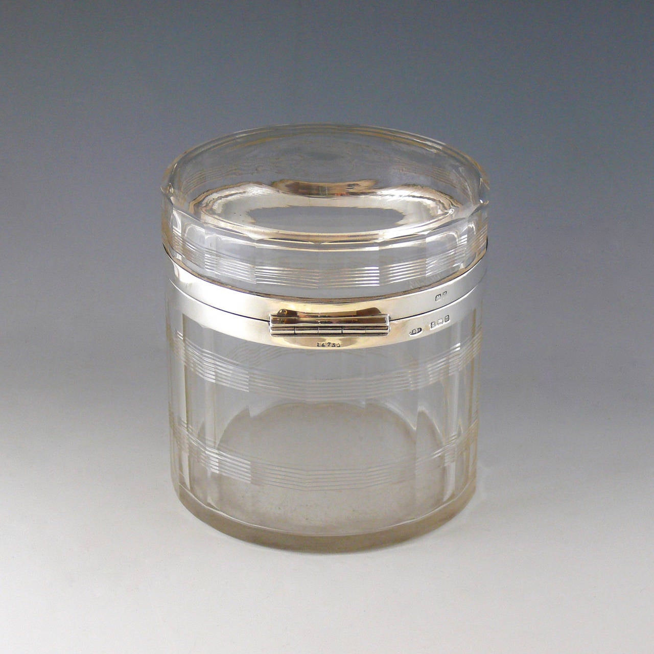 A wonderful fluted cut-glass and silver bound jar with hinged lid, hallmarked, Birmingham, 1911.

Dimensions: 12 cm (diameter) x 12.5 cm (height).

Member of LAPADA.