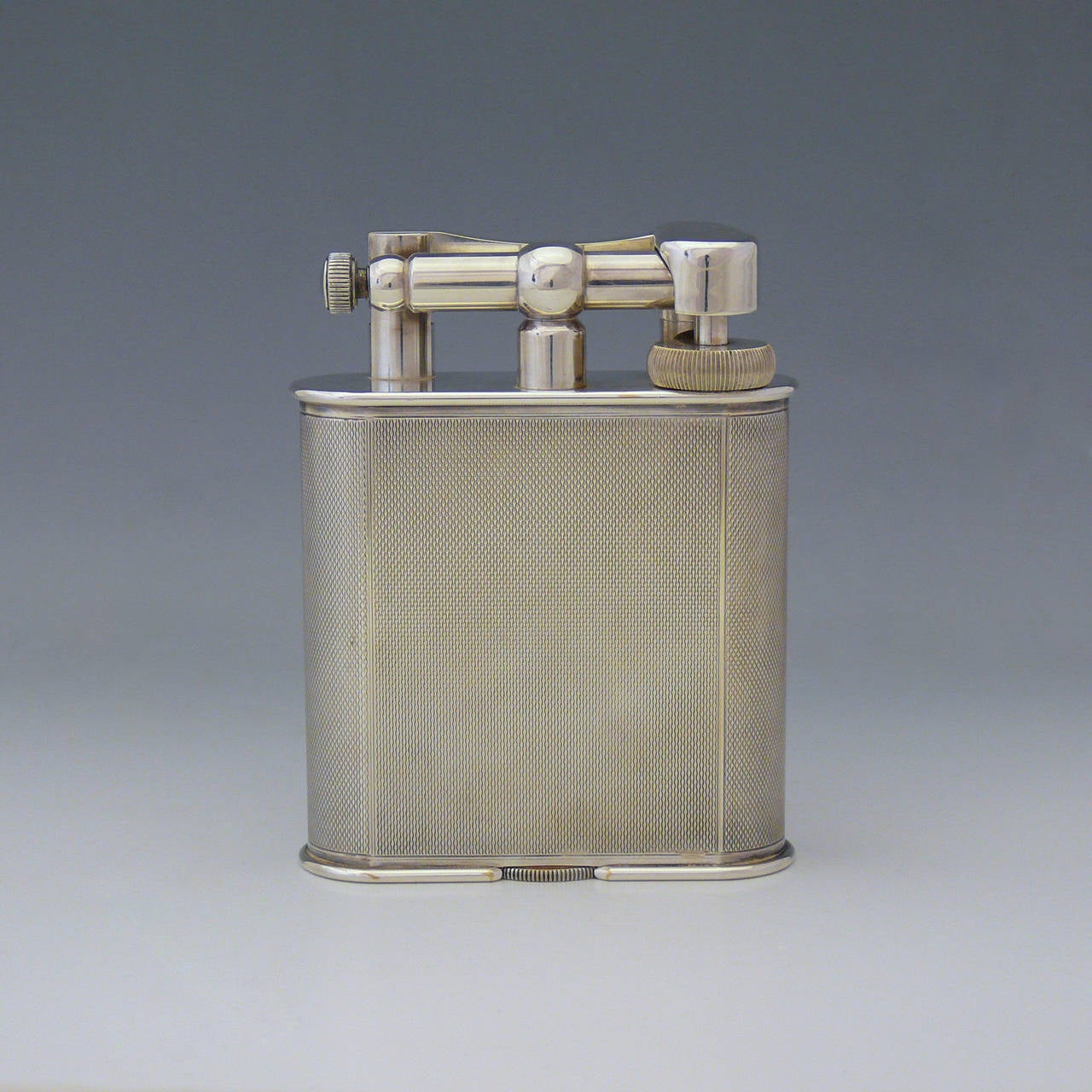 An excellent Dunhill 'Giant' lighter in engine turned silver plate, circa 1950. Fully serviced by Dunhill.

Dimensions: 8 cm (width) x 10.5 cm (height).

Member of LAPADA.