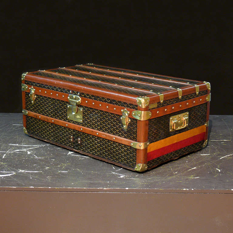 A wonderful Goyard cabin trunk with original tray and interior, and with red and orange painted livery to the ends. Circa 1925.

Dimensions: 85 cm x 52 cm x 36 cm