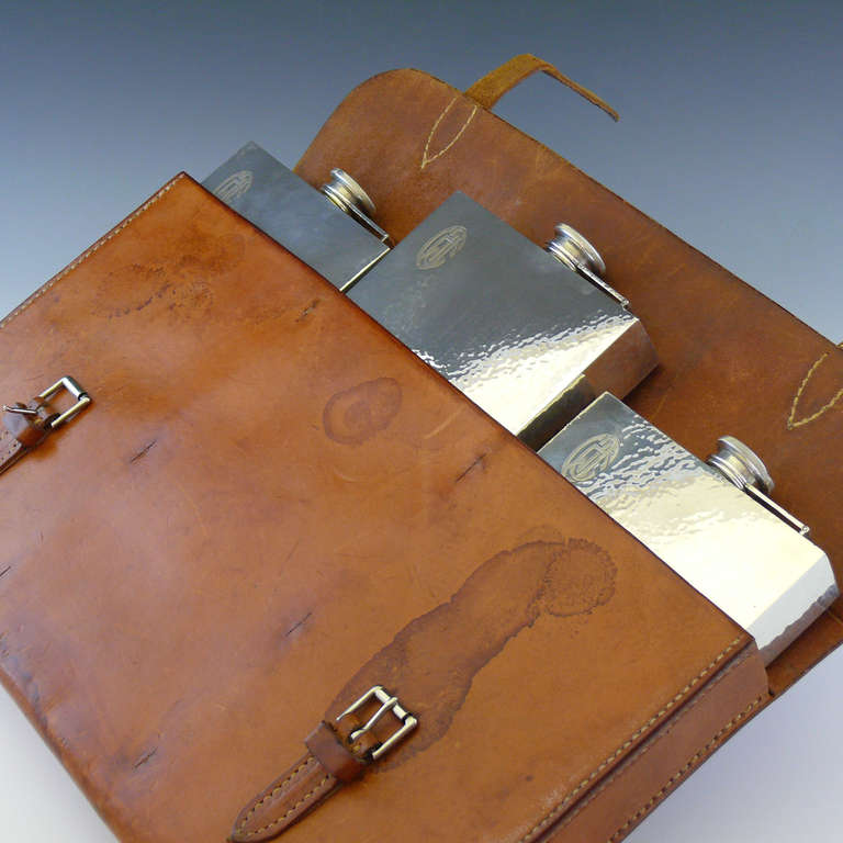 A rare item from Prohibition era America. The leather 'document style' case conceals three 2 pint spirit flasks in hammered silver, marked sterling, circa 1925.
The purpose of the case was to allow an individual to transport illicit liquor during