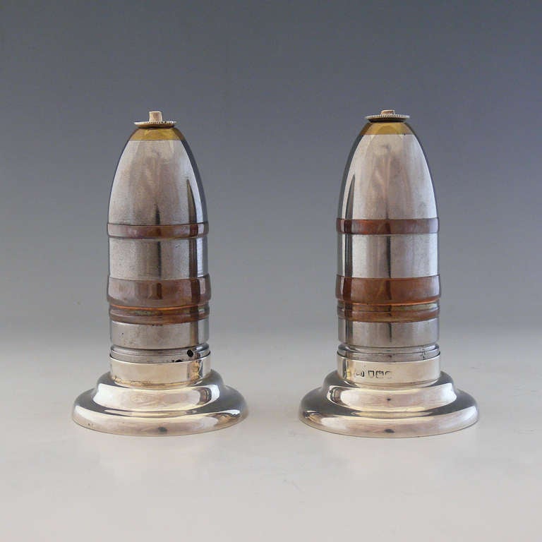 A fabulous pair of table cigar lighters made from one pounder 'Pom-pom' artillery shells. To create the lighters these nineteenth century shells were mounted with silver tops and bases; hallmarked London 1900.

Dimensions: 11 cm (height) x 6.5 cm