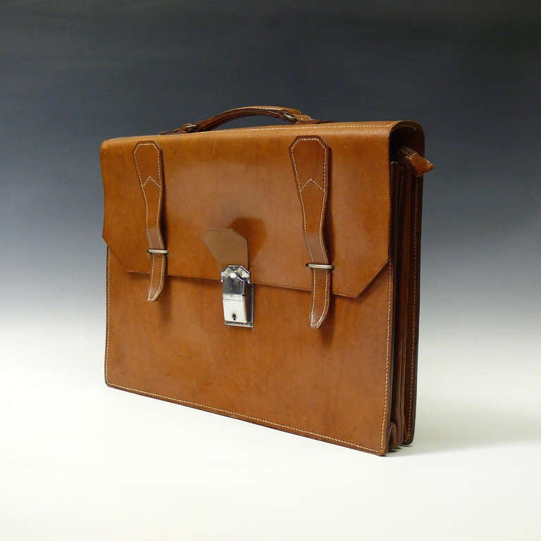 A fine mid tan three section leather briefcase with nickel-plated catch or lock and 'loop & strap' fastenings. The middle internal section has a full length zip fastener, circa 1935.

Dimensions: 40.5 cm (width) x 31 cm (height).

Member of