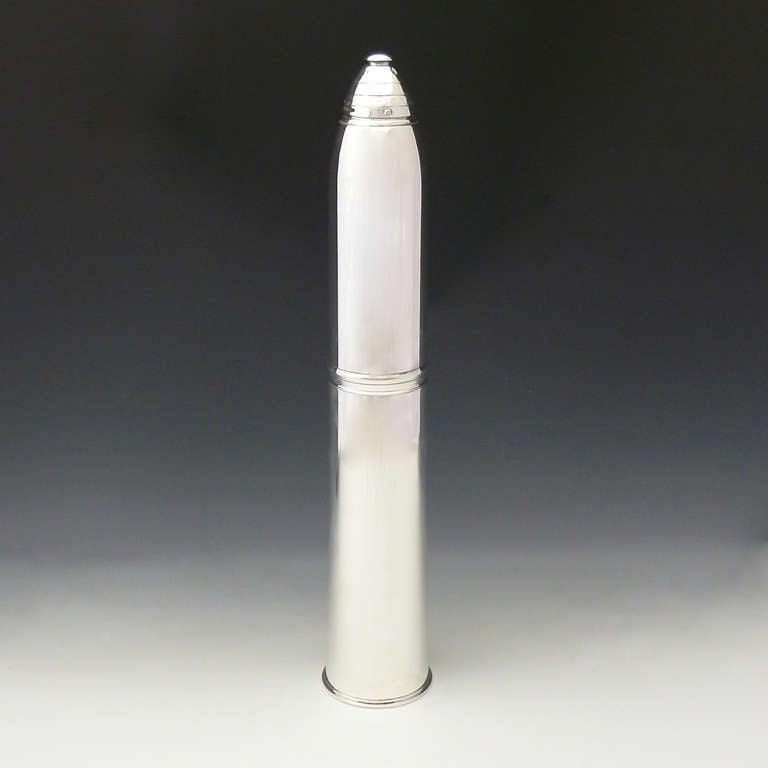 A magnificent silver plated cocktail shaker in the form of a WWI artillery shell, the shaker comes with a set of four glasses.

Dimensions: 57 cm (length) x 10 cm (diameter)
