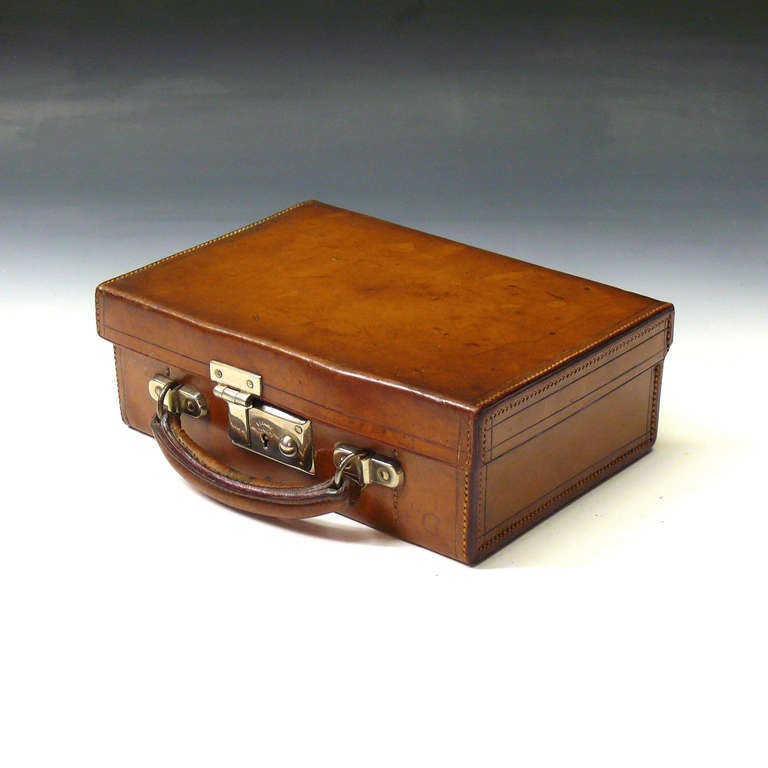 A charming continental leather cased picnic set for two. The nickel plated fittings of the set comprise; a sandwich tin with enamel liner and two beakers. There are also two vertically fluted cut glass flasks with nickel plated tops and four