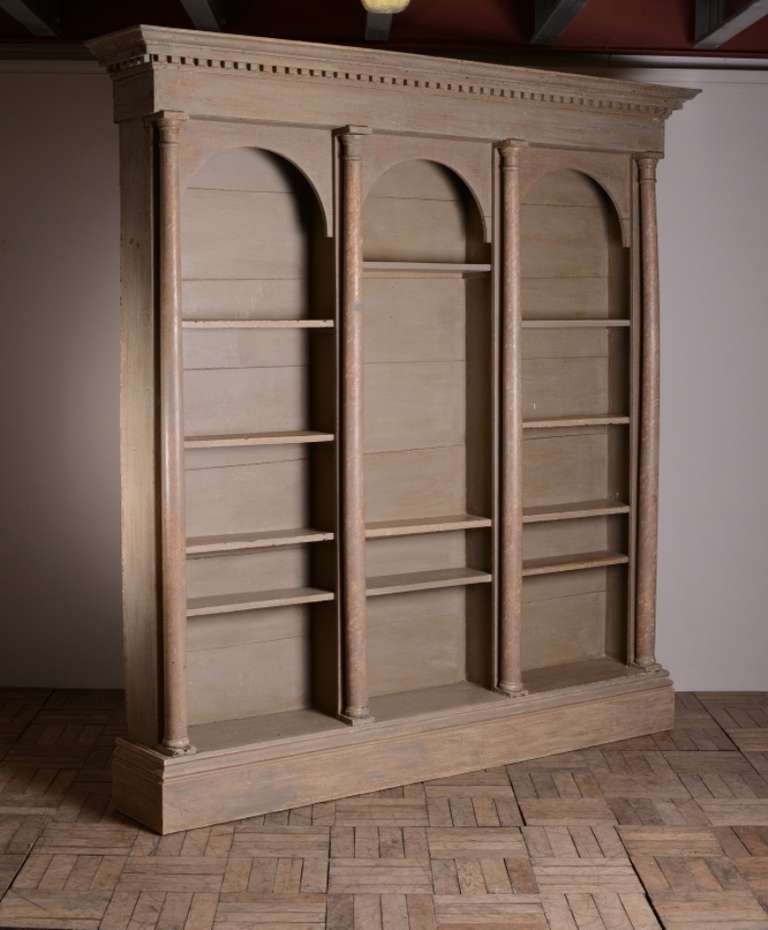 Architectural Irish Georgian Antique Bookcase.
This is an impressive sized, Georgian antique open bookcase.
The painted pine antique bookcase features four strongly architectural whole columns, fine dentil mouldings to the cornice and three arched