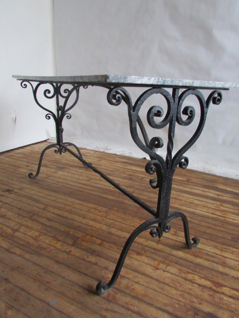 Large French hand wrought black iron and marble console / work table / pastry table. The original marble top with great color & veining w/ beautifully aged wear as this table was long ago also used as a cutting table in an old flower shop.
