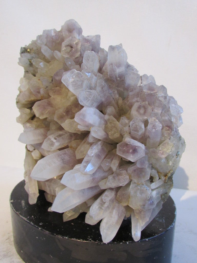 Old large natural quartz crystal cluster. Purple hue to the points and many small gold mineral inclusions. Can be set on stand in a number of different ways as there are three rough sides to specimen