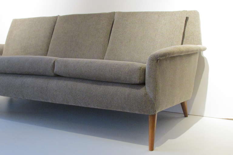 A Folke Ohlsson attributed three seat sofa for Dux with sleek tapered honey colored birch legs. Reupholstered with a beautifully textured nylon velvet fabric and new foam fill. The sofa retains the original Dux label.