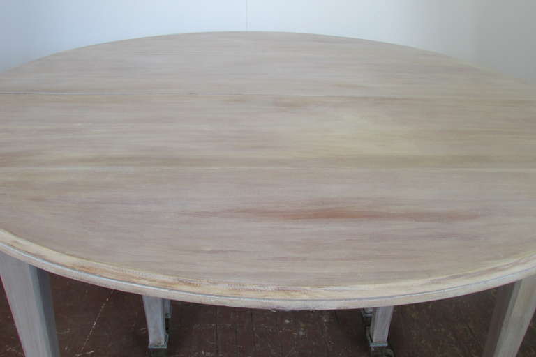 Antique 19th century French round drop leaf extension dining table with a bleached & limed finish to beech wood. Measures 55 inches in diameter in round and 29.5 inches high, with drop leaf down it measure 29 inches x 55 inches. This table can