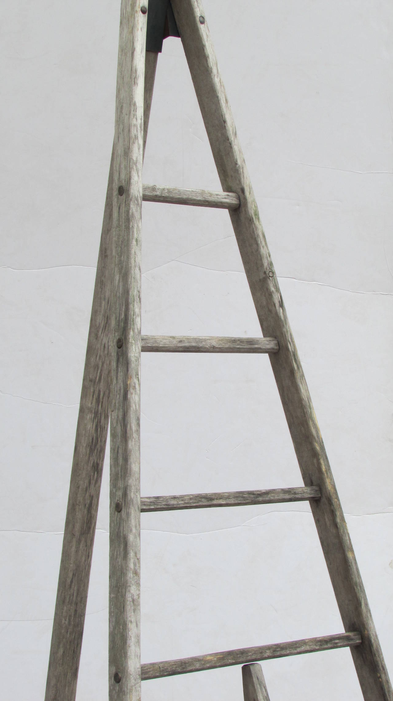 From an old Western New York State orchard a thee legged folding wood harvest ladder with beautifully aged pale gray weathered surface and a very sculptural  peak topped tapered pyramidal architectural form