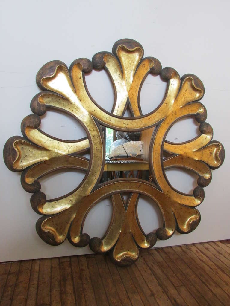 A spectacular mid 20th century Baroque style carved pine gilt wood sunburst mirror with large scale architectural proportions. An eye dazzling statement piece.