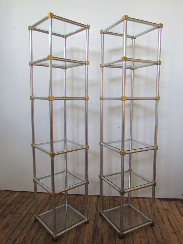 A very high quality pair of sleek classical modernist etageres in the style of Karl Springer. Each with six glass shelves & finely constructed of highly polished aluminum and joined with gilt bronzed brass cubes at all four outside corners of every