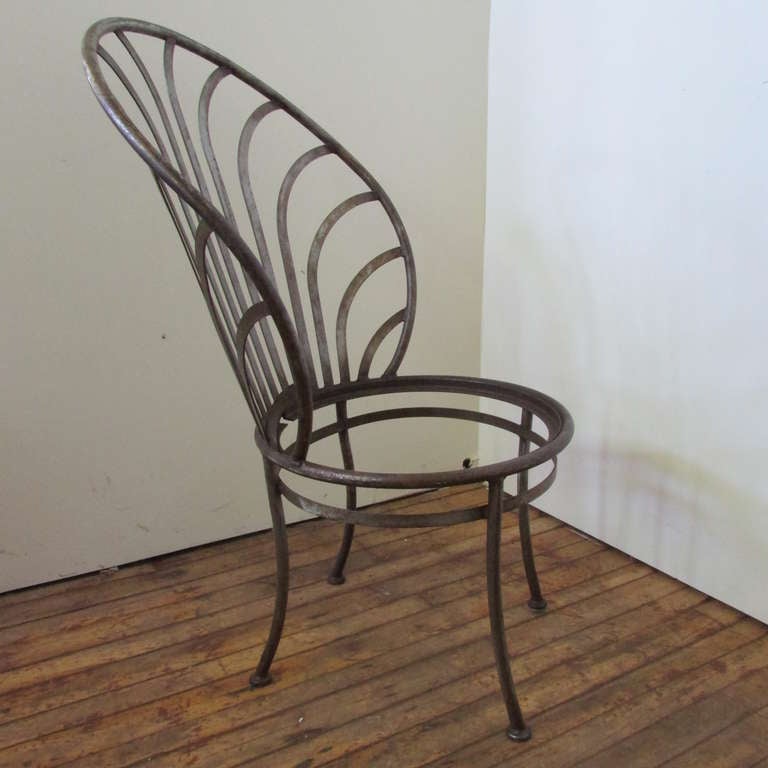 A set of four mid 20th century Arthur Umanoff tall scallop back steel chairs manufactured by Shaver - Howard - North Wilkesboro, North Carolina. They are all original as found, each with aged patina to the metal and a beautiful curvaceous style