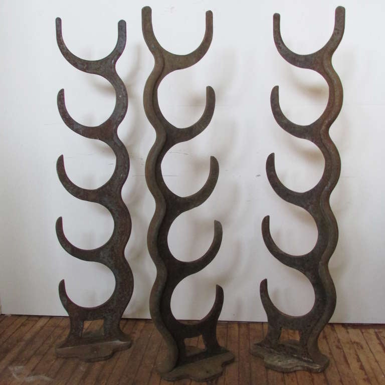 Three tall antique cast iron industrial factory pipe racks. Whimsical surrealistic modernist tree like forms with beautifully aged old worn painted surface and color to iron.  Many creative utilitarian applications possible ( shelving ends / pot