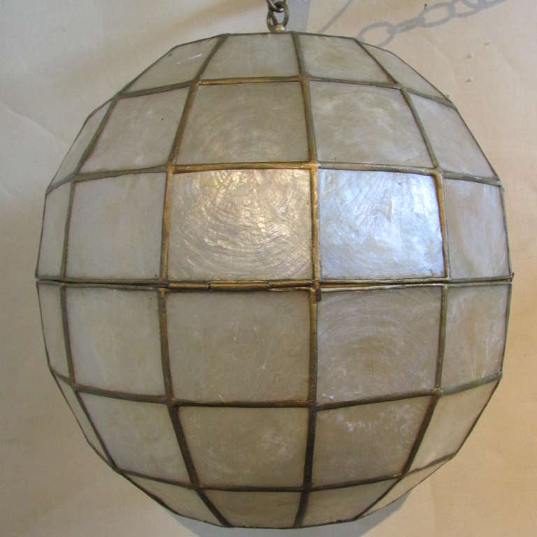 Mid 20th century large ball form capiz  pendant chandelier in very good as found working condition with overall nicely aged color & patina to shell and metal. Lamp has the original long metal link hanging chain, electrical fittings - socket, plug