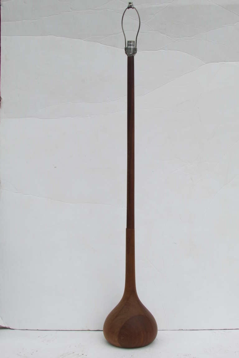 1960s Scandinavian modern teak floor lamp with a sculptural bulbous base. All original good working condition with nicely aged color and patina to wood. Measures 57 inches high to finial, 48 inches to top of wood shaft and ten inches across base.
