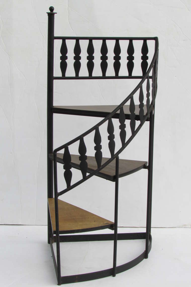 A spiral library stair with a black wrought cut steel welded frame and three elongated triangular wood steps . Heavy strong solid quality construction and 100% functional. The height to the top step is 24 inches. The height to the ball finial at top