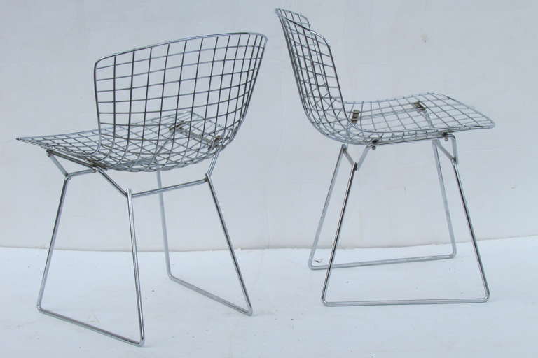 A pair of vintage Harry Bertoia for Knoll welded steel wire side chairs in original chrome finish. Structurally perfect.